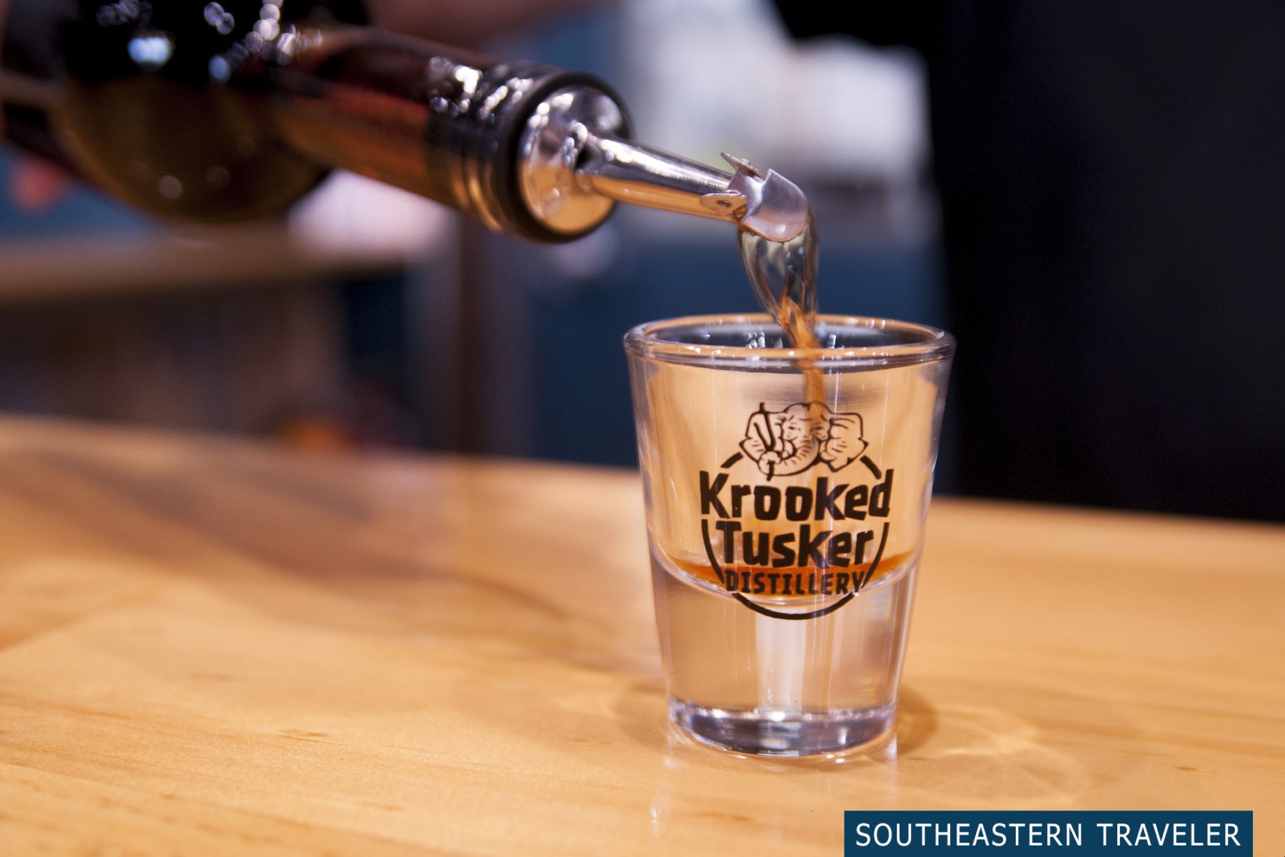 Pouring a shot glass of whiskey at the Krooked Tusker Distillery in Hammondsport, New York