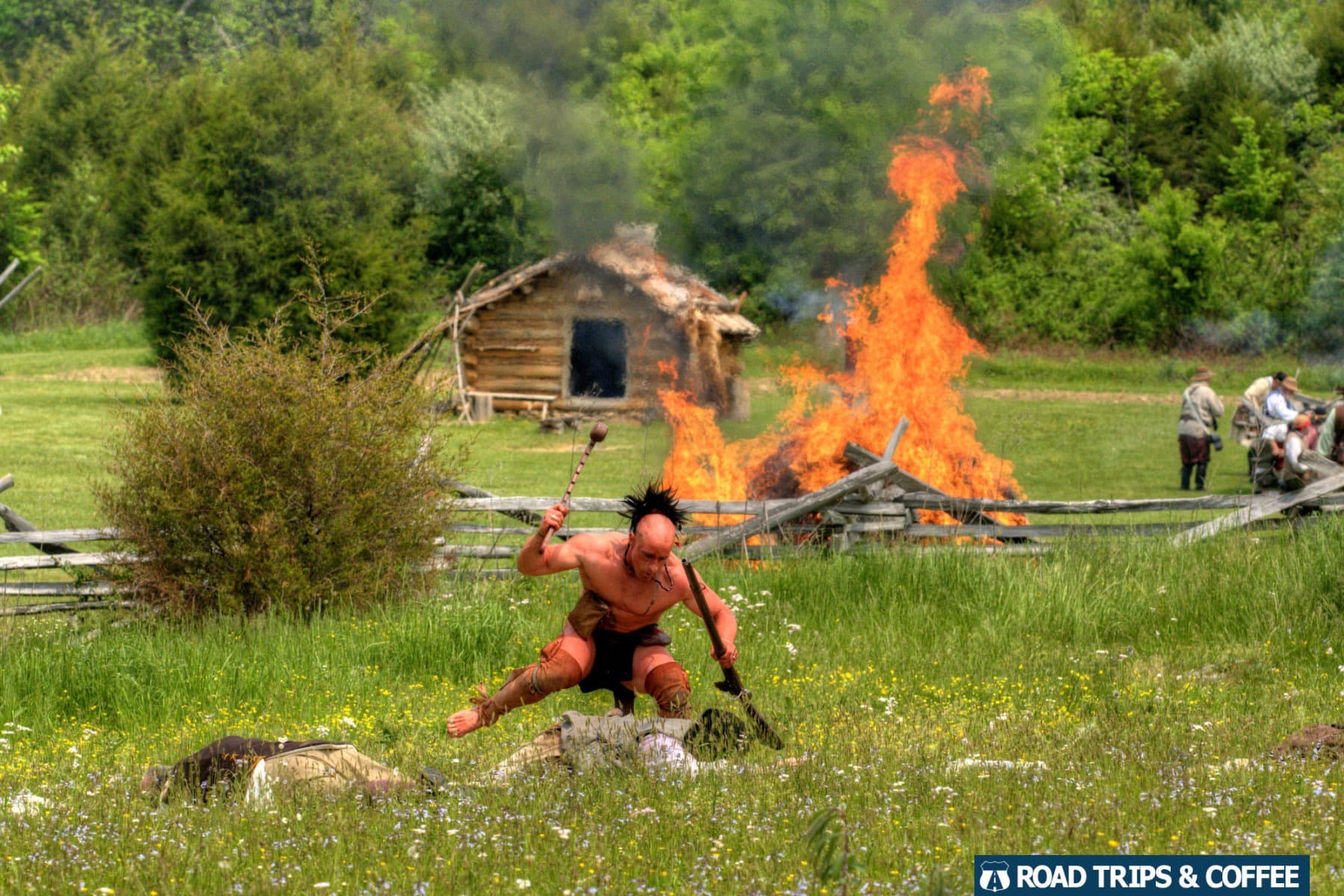 A fire burns in the background as a Cherokee reenactor attacks a Colonial reenactor during the Raid at Martin's Station at Wilderness Road State Park in Virginia