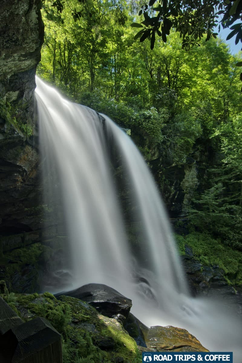 A roaring waterfall spills over a ledge and into a ravine at Dry Falls in Highlands, North Carolina