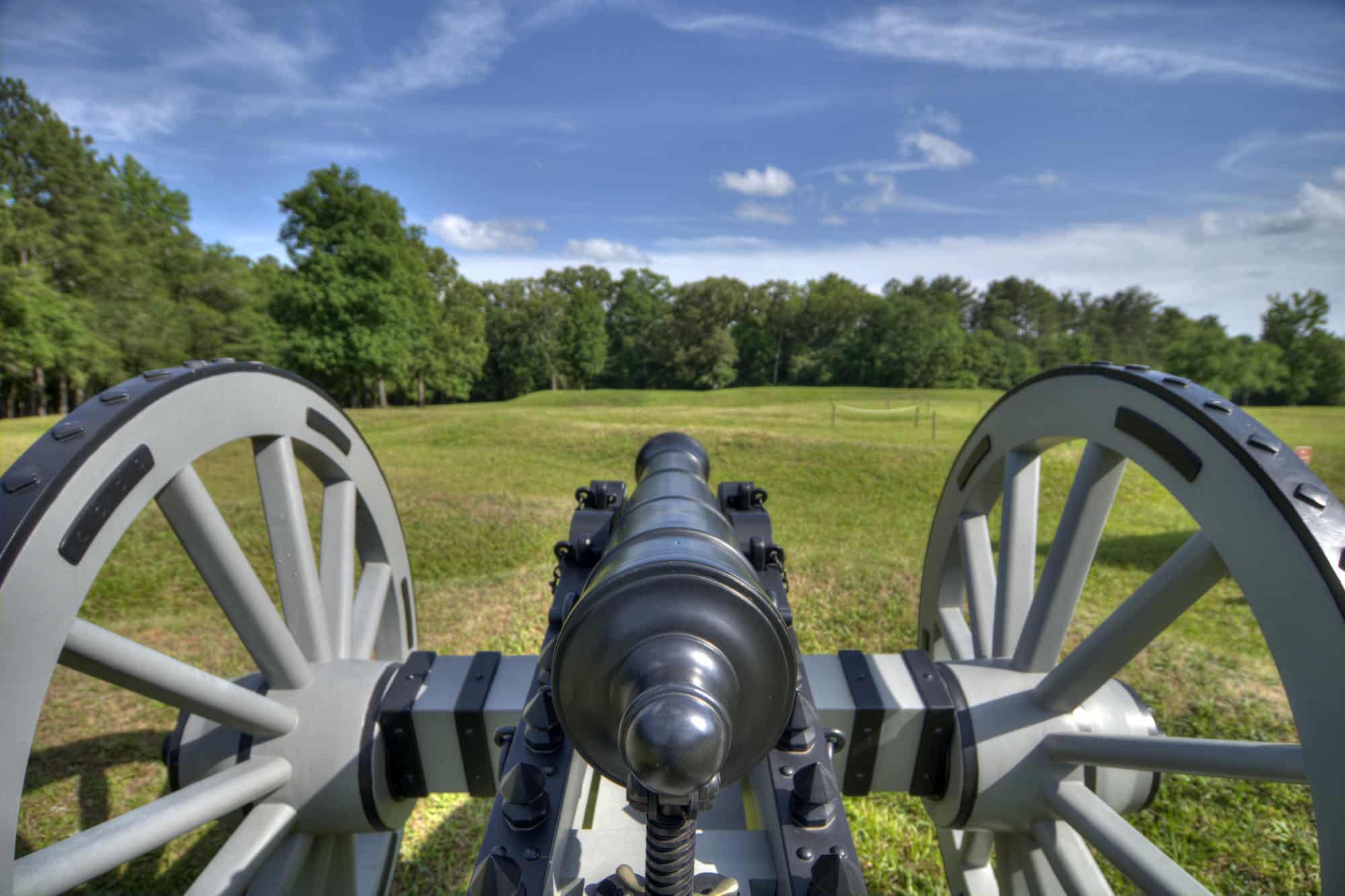 A canon pointing toward the earthen Star Fort at Ninety Six National Historic Site in South Carolina.
