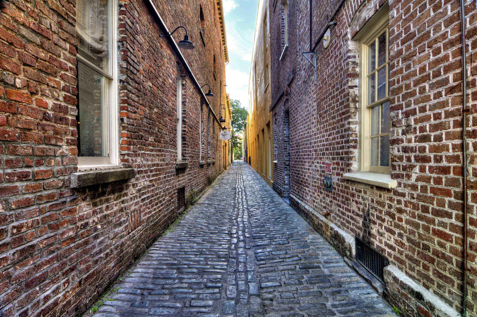 A narrow brick alleyway between two brick buildings in downtown Charleston, South Carolina.