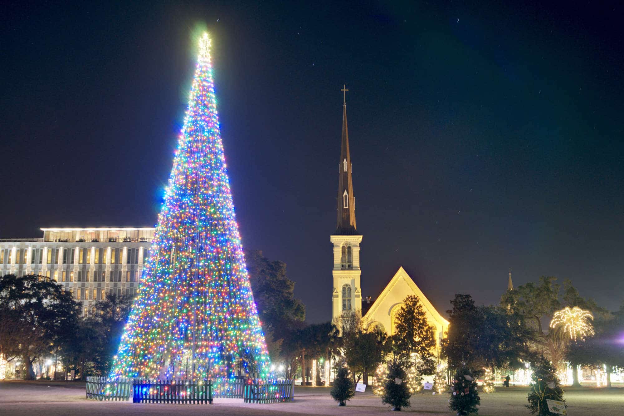 Strands of lights in a conical shape in the middle of Marion Square balance a nearby church's steeple in Charleston, South Carolina.