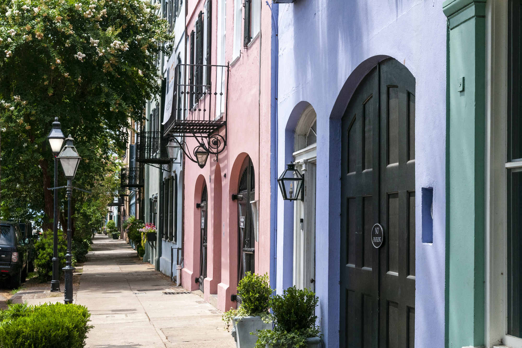 Colorful homes line an empty sidewalk, locally called Rainbow Row, in Charleston, South Carolina.